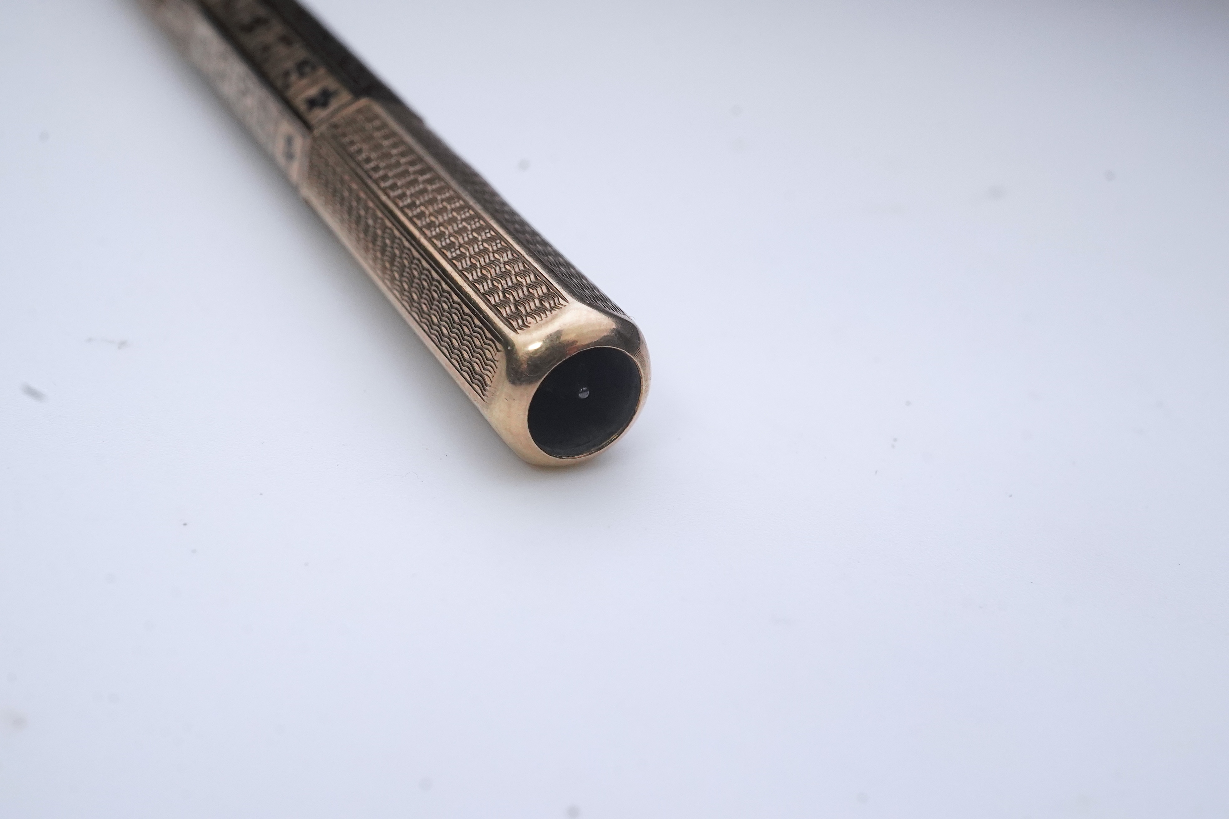 A gold calendar pencil and a gold pocket stamp dispenser